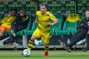 Mit dem Messi Satz zu Götze räumt der Bundestrainer Löw einen möglichen Fehler ein und sagt, er habe in dem Augenblick nicht an die Folgen gedacht, die dieser Satz auslösen würde. Das war für die Karriere für Mario Götze nicht wirklich förderlich. Wie kam es dazu Bei der Weltmeisterschaft 2014 hatte Götze den entscheidenden Treffer gegen Argentinien im Finale erzielt. Löw hatte den talentierten Spieler zuvor mit den Worten: „Zeig der Welt, dass du besser bist als Messi“ eingewechselt. Und Bekanntlicherweise zählt Lionel Messi zu den besten Fußballspieler der Welt. Publik wurde der Satz, als der Bundestrainer Jogi Löw später in einem Interview zu diesem Szenario befragt wurde. Es wäre ein spontaner Einfall gewesen, so Löw später, und ob das im Nachhinein ein guter Einfall war, konnte der Bundestrainer auch nicht mehr sagen, da Götze an diesem Satz gemessen wurde und so der Druck für den Spieler stieg. Hat ein Fußballspieler bereits in so jungen Jahren so ein Schlüsselerlebnis, kann die Belastung sehr groß werden und Mario Götze wäre nicht der erste Spieler, der an aufgrund dieser Belastung scheitert. Mario Götze, gehört zu den Fußballern, die stetig öffentlich kritisch beäugt werden. Ob Meldungen aus seinem Privatleben oder aus dem fußballerischen Bereich, Mario Götze muss sich stetig mit den Medien auseinandersetzen. Man ist gut beraten, über sein Privatleben möglichst wenig preiszugeben, da aufgrund seiner Fußballkarriere bereits genug in den Medien zu lesen ist. Götze überzeugte selten in der Bundesliga Der jetzt 25-jährige Fußballer, die seine Karriere bei Borussia Dortmund begann und seit 2013 Spieler des FC Bayern ist, musste anfangs sehr kämpfen und konnte nicht den großen Stellenwert erreichen, den er sich selbst gewünscht hatte. Vielleicht war auch das der Grund dafür, das er 2016 zurück zum BVB wechselte. Allerdings setzte ihn eine unangenehme Stoffwechselstörung monatelang außer Gefecht, sodass er die Rückrunde 2016 komplett verpasste. Da Götze in der Bundesliga selten überzeugte, wurde er vom Bundestrainer Löw nicht für die WM im Sommer in Russland nominiert. Jogi sagte hierzu, dass Mario nicht der begnadete Fußballer war, den man sich wünschte und er nicht die gewünschte Leistung erbrachte. Daher entschied der Bundestrainer sich gegen Mario Götze und sagte, es wäre für ihn vielleicht besser, dass nächste Mal wieder dabei zu sein, wenn er zu seiner alten Form zurückgefunden hätte. So bleibt Mario Götze nichts weiter übrig, als sich mental neu zu sammeln und Kraft für die nächste EM oder WM zu sammeln. Erst wenn er zu seiner alten Form zurückfindet, wird Löw ihn auch wieder nominieren. Ob dieser Druck für den Profifußballer zu groß ist, wird sich Rausstellen. Denn auf einen Profi, der die Nerven behält, wenn es darauf ankommt, wie in bei WM 2014 kann jeder Bundestrainer brauchen. Und ein Formtief darf jeder Profi einmal haben, wichtig ist es, in den entscheidenden Momenten die nötige Professionalität an den Tag zu legen und sein Fußballtalent zu zeigen. Bleibt zu Hoffen, das Mario Götze beim BVB wieder zu seiner alten Form zurückfindet.
